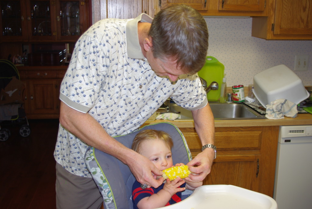 Uncle Aaron helping Finn with his first corn on the cobb